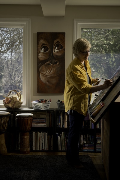 Cynthia Fox paints a lovely piece in her Peterborough home studio, while the eyes of a monkey watch closely. Light carefully by photographer Mike Taylor, this portrait is intimate and restful.